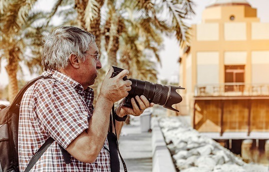 Senior im Urlaub mit Kamera